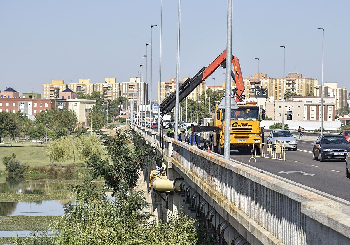 Una grúa reparando una de las averías en la tubería del puente de la Universidad.
