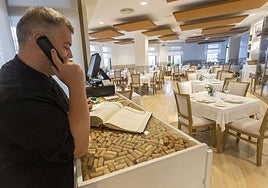 Juan Miguel Palacios, chef y gerente del restaurante Albalat, atiende una llamada mientras consulta el libro de reservas. En este establecimiento ya hay cuatro días llenos con comidas de empresas.