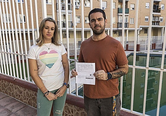 Estefanía Píriz y Guillermo Anselmo, con el recibo de la tasa de basuras que ha recibido su comunidad de propietarios.