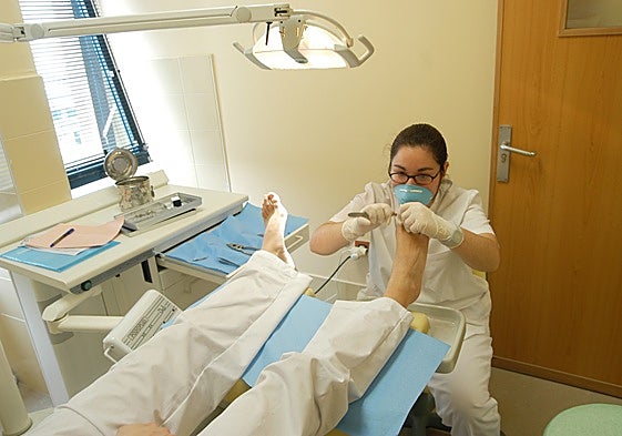 Una podóloga atiende a un paciente.