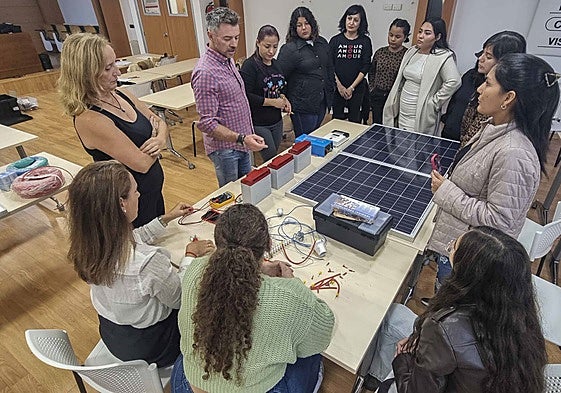 Víctor Corchón, docente del curso, explica a las mujeres el uso de la electricidad y los paneles.