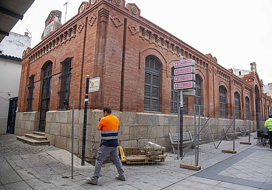 Un operario coloca este viernes una valla junto al edificio una vez que Ferrovial ha iniciado oficialmente la actuación.