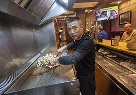 Wang Shi, más conocido como Felipe, haciendo pinchos en 'La Bodeguilla', un mítico bar de Cáceres que dirige con la misma esencia que su antiguo dueño.