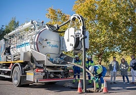 Un camión extrae residuos de la red de saneamiento en presencia de Fernández y responsables de Aqualia.