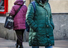 Dos mujeres pasean por la calle abrigadas.