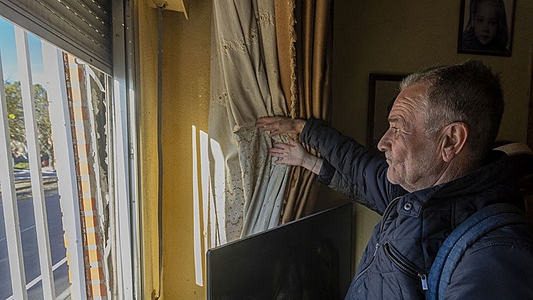 Manuel Morán, uno de los vecinos desalojados, muestra la separación existente de la fachada de ladrillo desde la ventana de su salón.