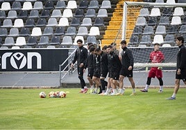 Los jugadores del Badajoz transportan la portería durante un entrenamiento.