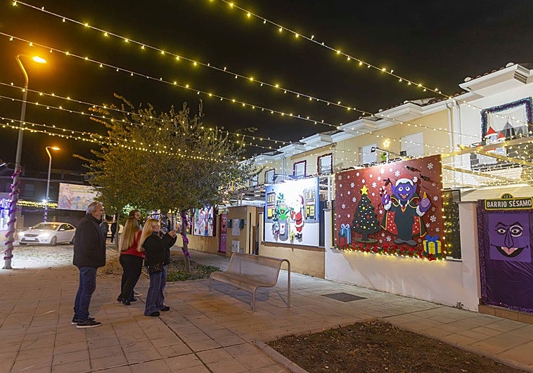 Unas personas hacen fotos a la decoración de una vivienda en la calle Berlanga, de Montealto