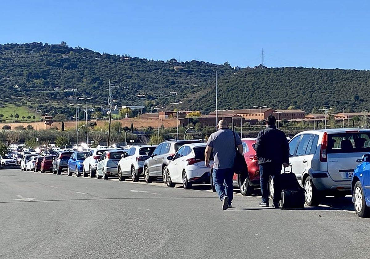 Dos peatones caminan por la calzada a la salida del hospital al estar la acera (a la derecha) ocupada por los coches.
