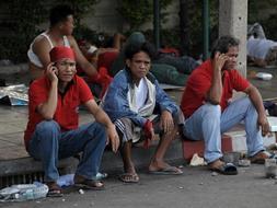 Seguidores de Thaksin Shinawatra descansan en el exterior de la sede del Gobierno en Bangkok. / Afp