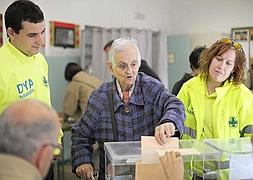 Voluntarios de la DYA acompañan a una anciana a votar en Pamplona/  Efe