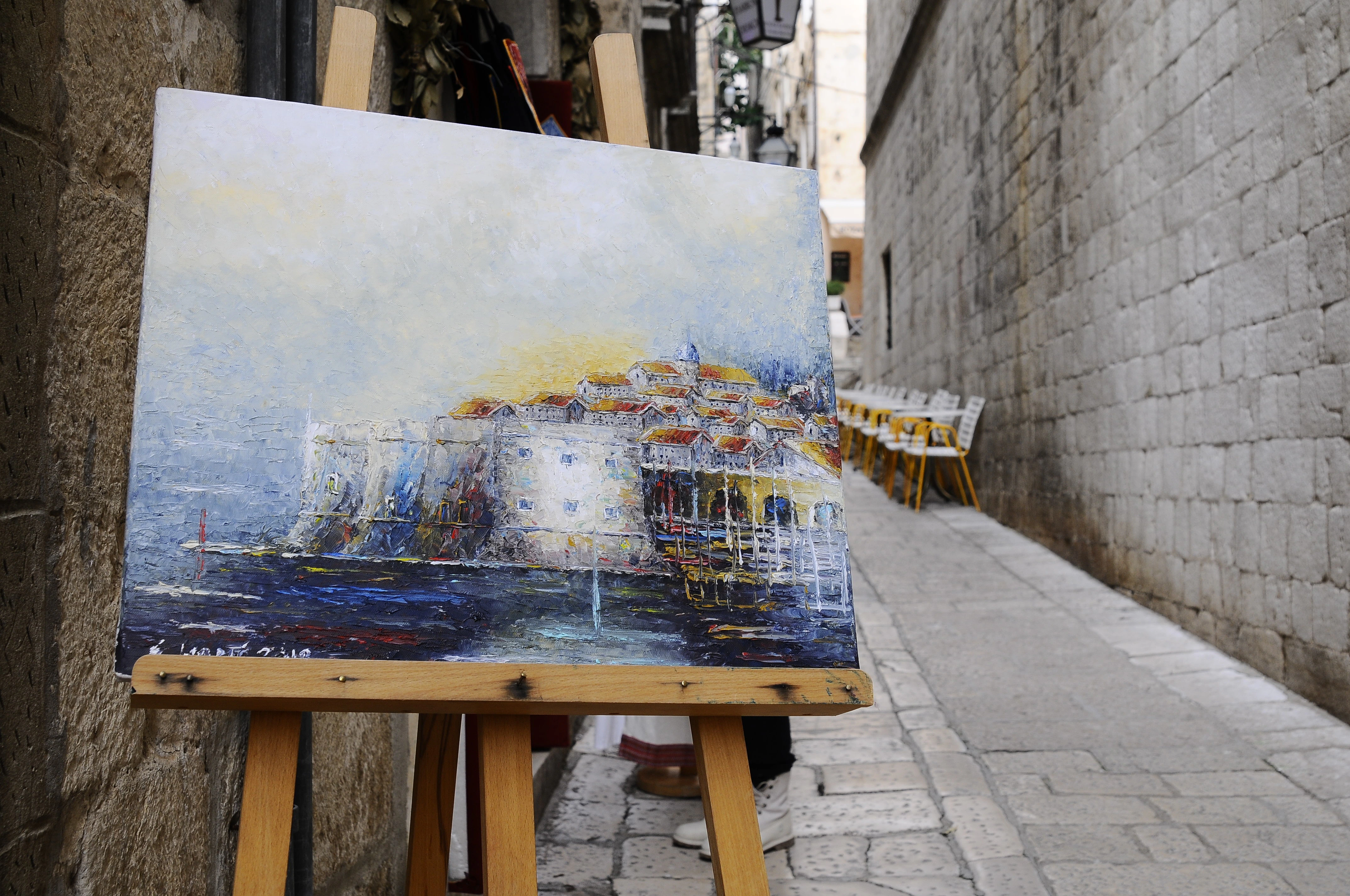 Pintura de la vista de la ciudad amurallada de Dubrovnik en una de sus calles.