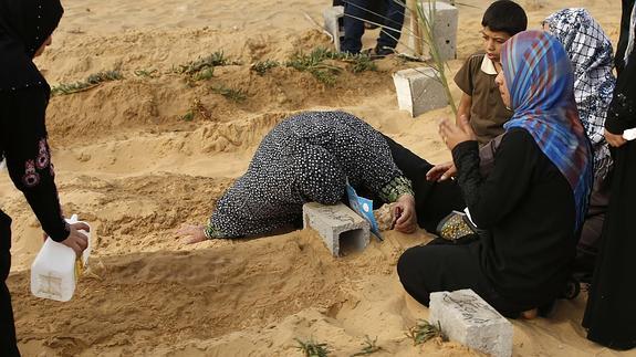 Una mujer palestina llora sobre la tumba de su hijo.