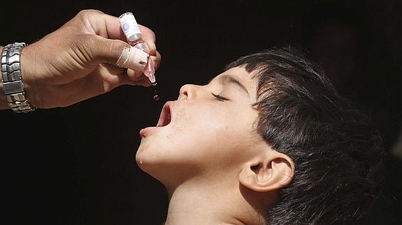 Un trabajador de la sanidad afgana administra unas gotas de polio a un niño en Herat (Afganistán) 
