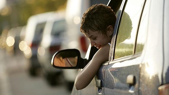 Una joven conduce su coche.