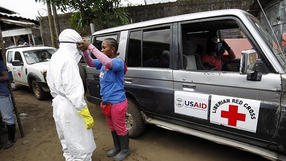 Un grupo de personas perteneciente al equipo que transporta a las víctimas de Ébola se prepara para dirigirse a la comunidad Point Four, en Monrovia (Liberia) 