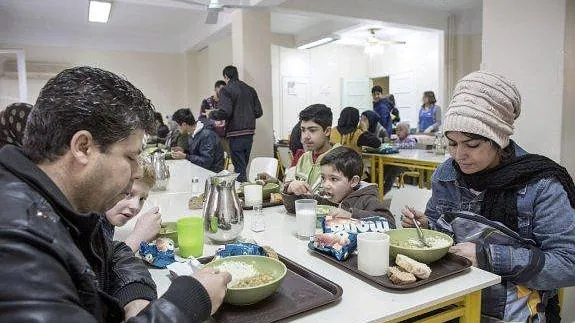 Varias personas acuden a un comedor social de Cáritas en Agenas (Grecia).