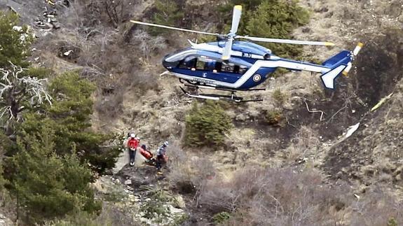Un helicóptero y varios miembros del servicio de rescate, en la zona del accidente. 