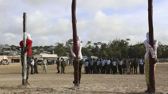 Tres hombres atados a postes esperan a ser ejecutados por un pelotón de fusilamiento, en Mogadiscio (Somalia).