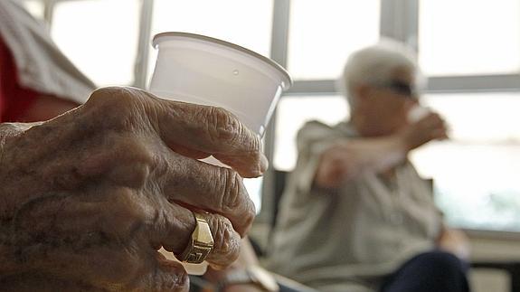 Ancianos beben agua en una residencia de la tercera edad.