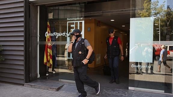 Efectivos de la Guardia Civil, tras el registro en la sede de CDC. 