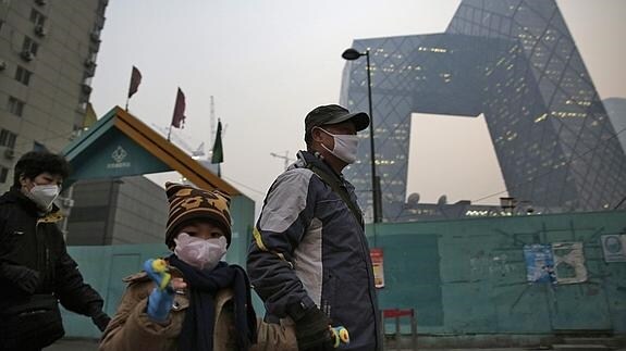 Un padre y su hijo usan mascarillas para protegerse de la contaminación en Pekín. 