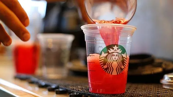 Un empleado de Starbucks sirve una bebida. 