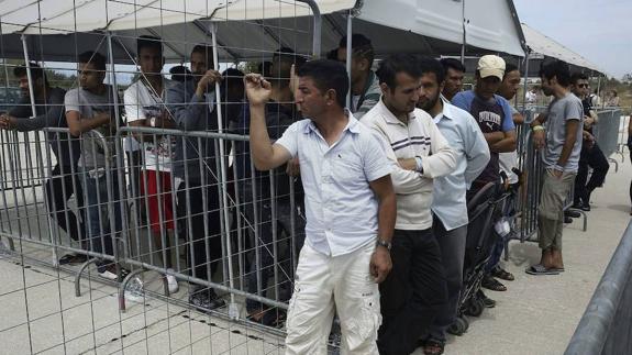 Refugiados y migrantes esperan para el proceso de pre-registro en un campamento de refugiados situado en el antiguo aeropuerto de Helliniko de Atenas, Grecia.