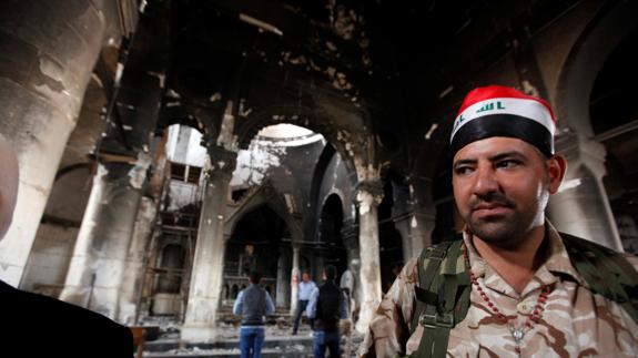 Soldado iraquí protege una iglesia recuperada al Estado Islámico