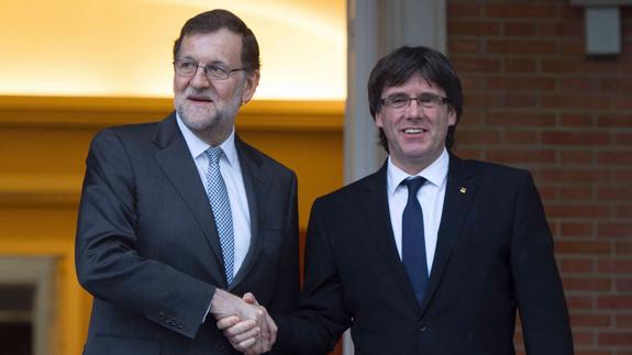 Rajoy y Puigdemont se saludan antes de un encuentro en Moncloa.