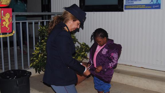 La niña con un agente de la Policía italiana.