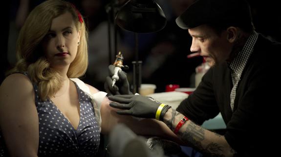 Una mujer se realiza un tatuaje. 