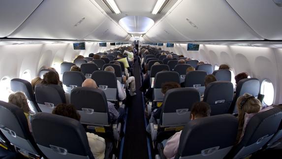 Vista interior de la clase turista de un avión de pasajeros. 