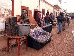 Un soldado saca a la calle los muebles de una vivienda.|ARCHIVO