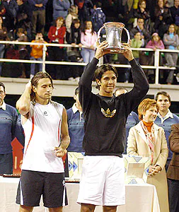 El tenista madrileño levanta la Copa de campeón, en presencia de David Ferrer, al que sometió ayer por 2-1.|JORGE REY
