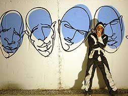 SUSO33. El afamado artista del grafiti posa tras una de las paredes del aparcamiento que está decorando con sus trazos./J.REY