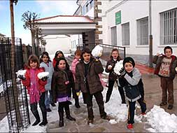 Niños y niñas de Piornal juegan con la nieve en la puerta del colegio. / PALMA