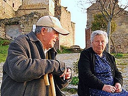 DE TERTULIA. Dos veteranos belvisos charlan tranquilamente en un banco a las puertas del castillo medieval de Belvís de Monroy.|ESPERANZA RUBIO