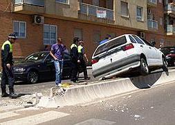 Un turismo queda suspendido en la mediana de hormigón en un accidente urbano