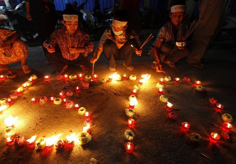 Camboyanos encienden velas y colocan flores como ofrendas en una ceremonia a los pasajeros desaparecidos del avión de Malaysian Airlines