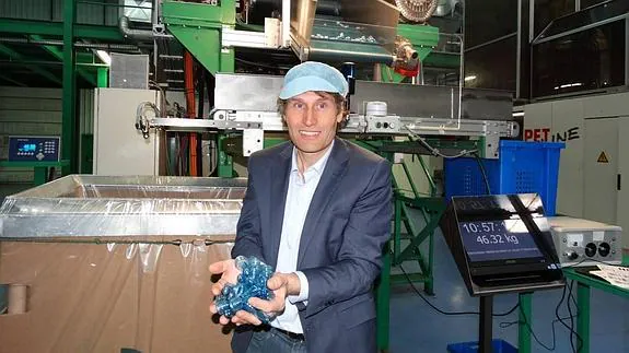 José Luis Quiñones, director de Resilux en España, muestra algunas preformas terminadas delante de la máquina que las elabora