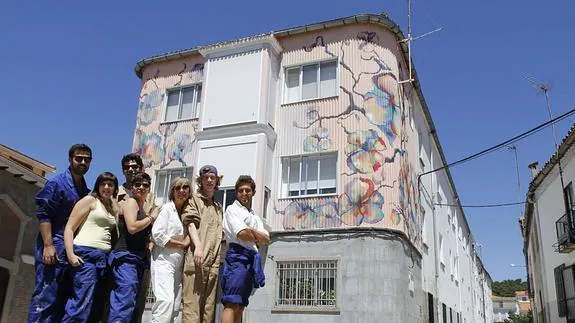 Estudiantes de la Universidad de Sevilla y su profesora delante de una de las fachadas que ya han pintado