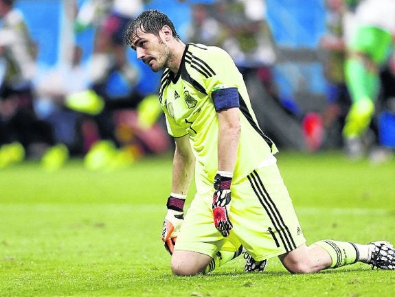 Arriba, 'La Roja' celebra la victoria de Sudáfrica. Abajo, Iker Casillas, desolado tras perder contra Holanda en Brasil. :: reuters
