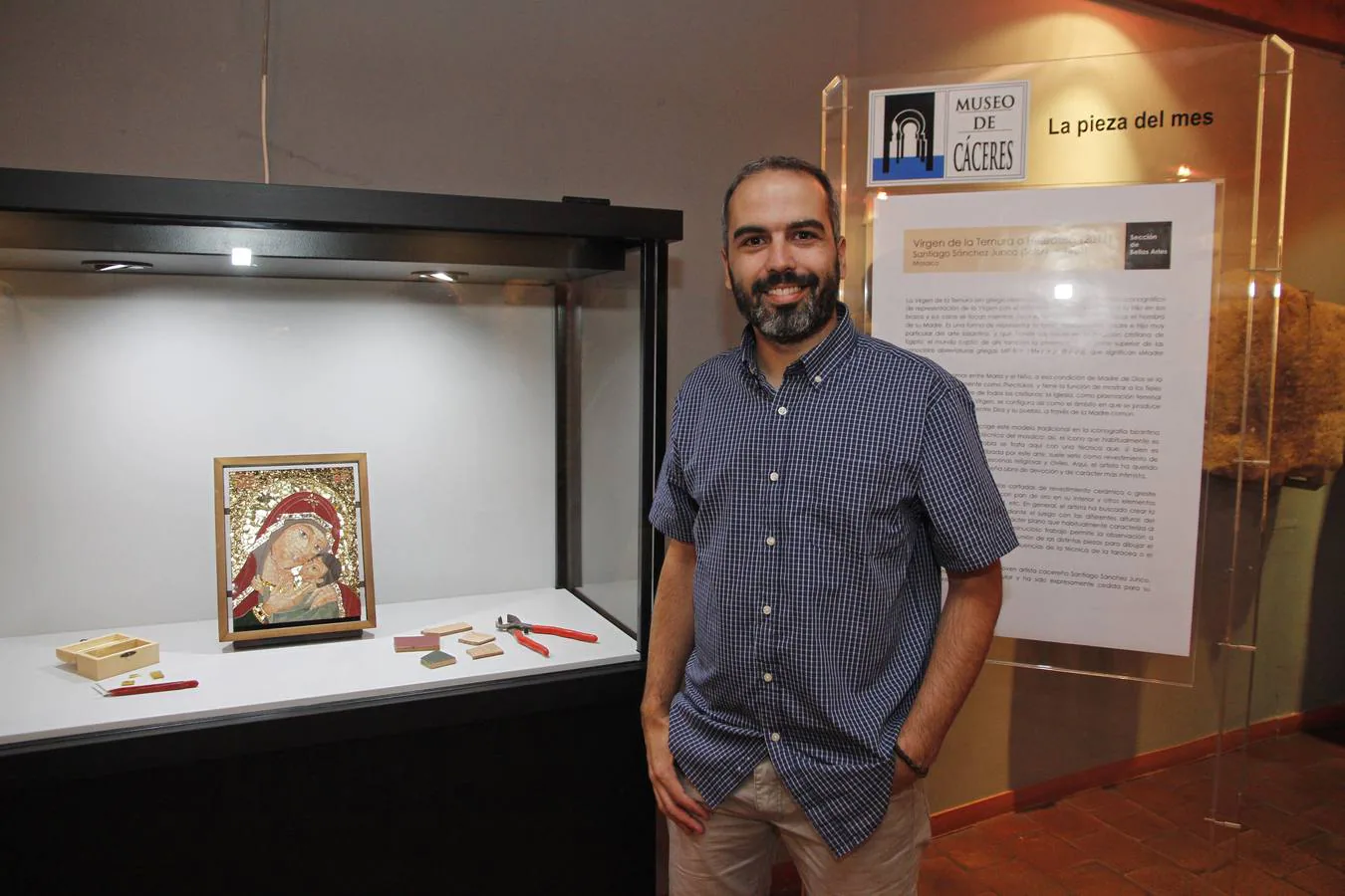 El artista Santiago Sánchez posa junto a la 'Virgen de la Ternura', pieza del mes del museo.