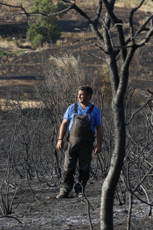 Ángel González, alcalde de Oliva de Plasencia, contempla la zona arrasada por el fuego. :: andy solé
