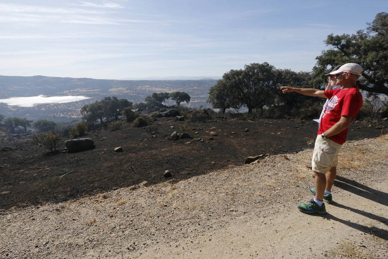 Dos hombres observan parte de la superficie calcinada en la finca Valcorchero de Plasencia