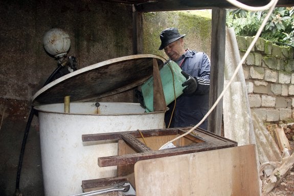 Un vecino llena con agua de la fuente su depósito de casa. :: m.n.