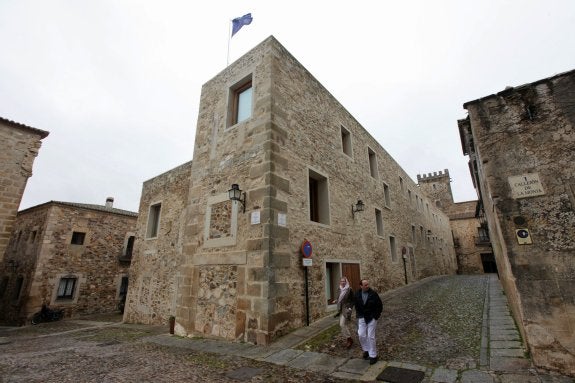 En primer plano, el hotel Atrio; al fondo, el palacio de los Golfines de Arriba. :: hoy