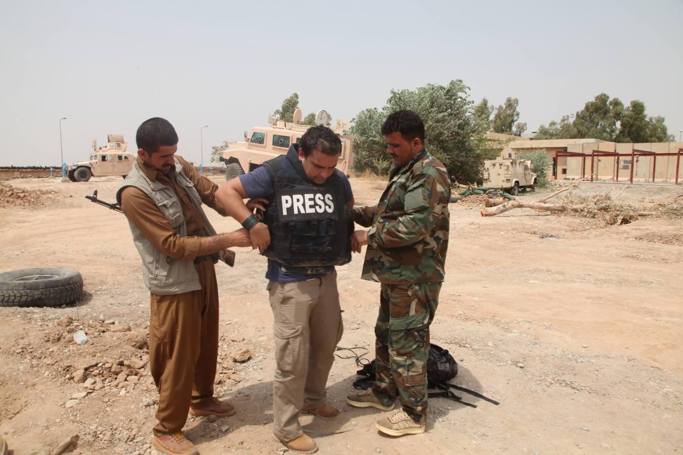  'Empotrado'. Dos 'peshmergas', combatientes kurdos armados, ayudan a Ángel a colocarse el chaleco antibalas antes de acercarse a la primera línea de fuego en Irak. :: HOY