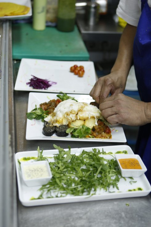 Un cocinero prepara varios platos en un restaurante vegetariano. hoy